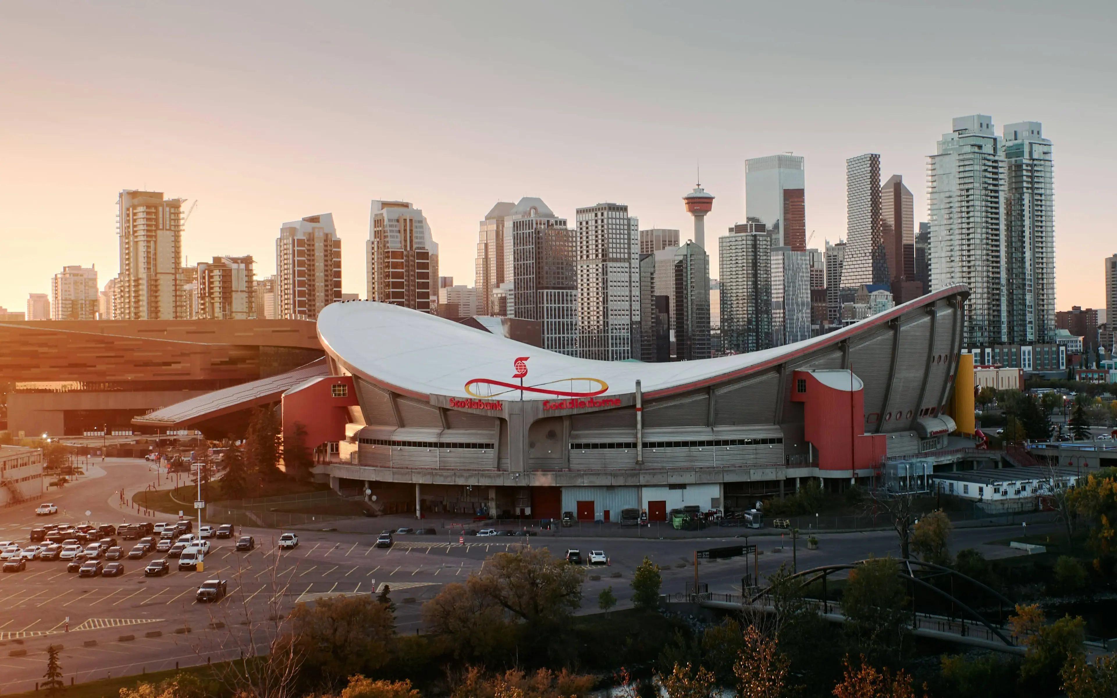 Calgary skyline featuring the Saddledome with downtown buildings in background during golden hour